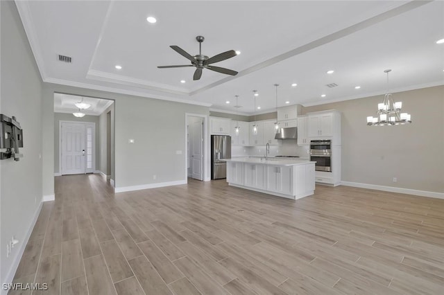 11912 Noveli Ct, Fort Myers, FL 33913 - unfurnished living room featuring light wood finished floors, a tray ceiling, baseboards, visible vents, and ceiling fan with notable chandelier