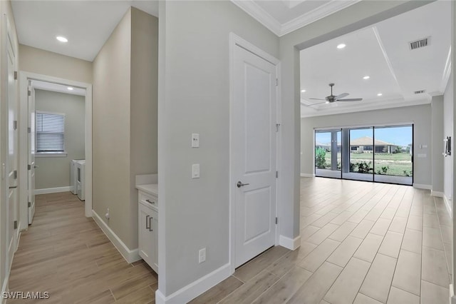 11912 Noveli Ct, Fort Myers, FL 33913 - hall with light wood-type flooring, baseboards, visible vents, crown molding, and washer and dryer