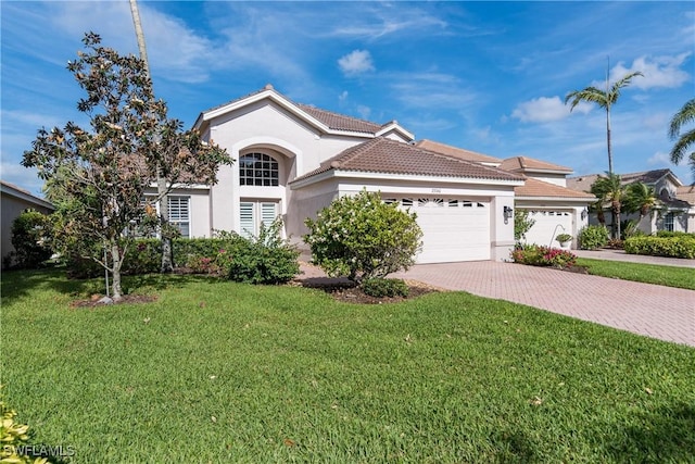 view of front of property featuring a front lawn, stucco siding, an attached garage, a tile roof, and decorative driveway