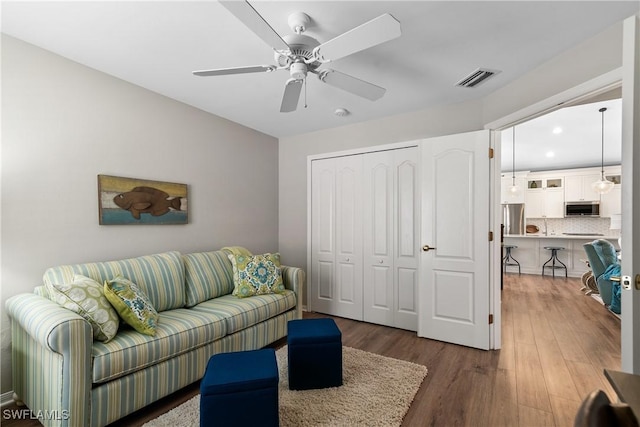 living area featuring recessed lighting, wood finished floors, visible vents, and ceiling fan