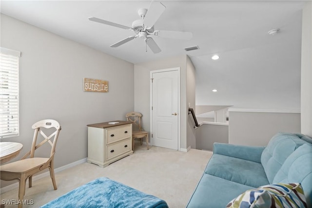 sitting room with visible vents, light colored carpet, ceiling fan, and an upstairs landing
