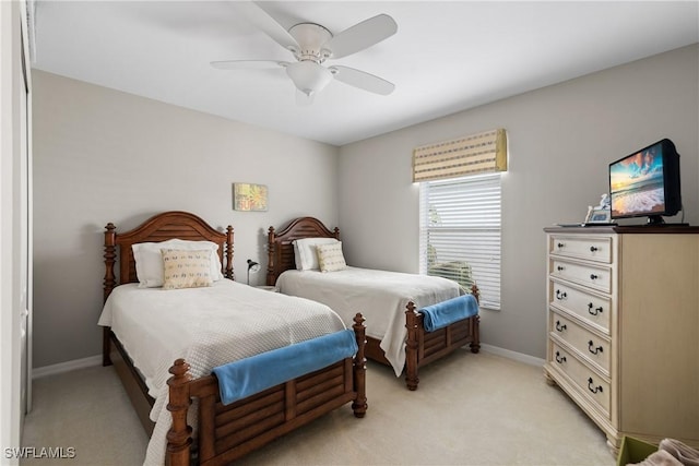 bedroom with ceiling fan, baseboards, and light colored carpet