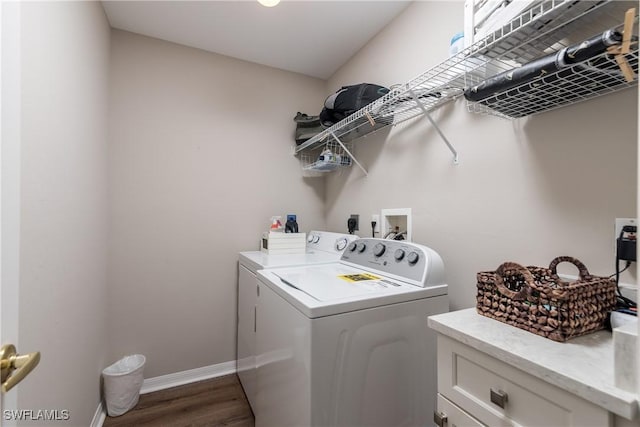 clothes washing area featuring washing machine and clothes dryer, baseboards, and wood finished floors
