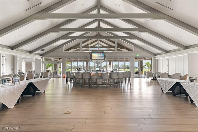 interior space with plenty of natural light, wood finished floors, and lofted ceiling with beams
