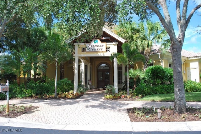 exterior space featuring a tiled roof and stucco siding