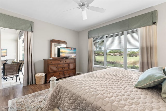bedroom with wood finished floors, baseboards, and ceiling fan