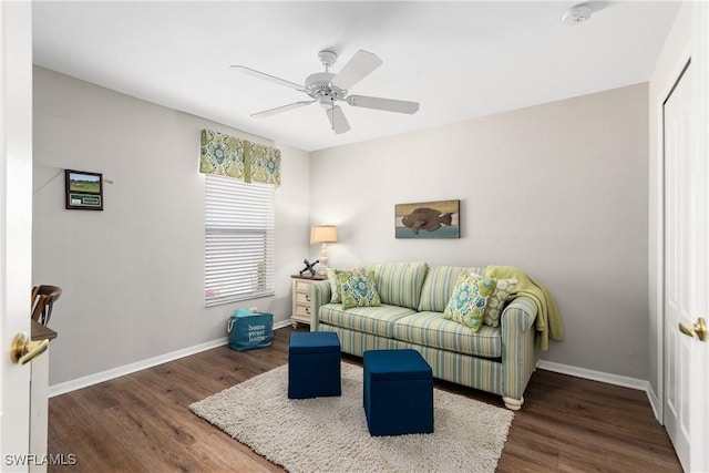 living area featuring baseboards, a ceiling fan, and wood finished floors