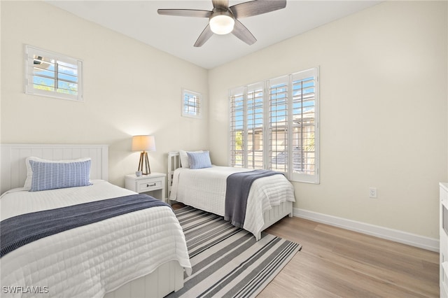 bedroom with baseboards, light wood finished floors, and ceiling fan