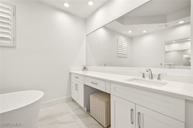 bathroom featuring a freestanding tub, vanity, recessed lighting, and marble finish floor
