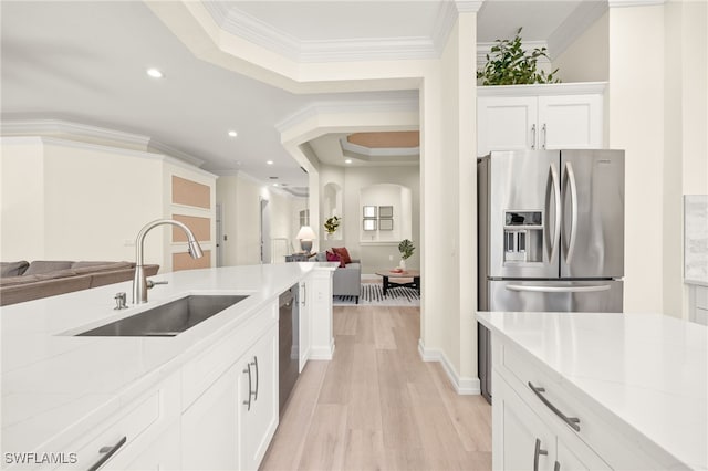 kitchen with light wood-style floors, a sink, dishwashing machine, and open floor plan