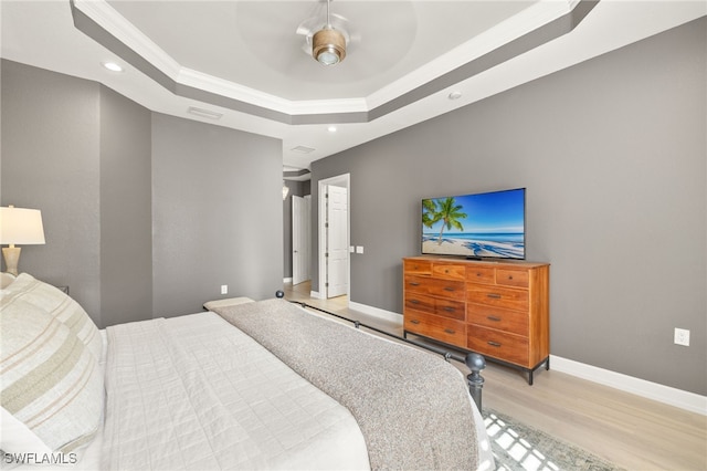 bedroom with a raised ceiling, recessed lighting, baseboards, light wood-type flooring, and ornamental molding