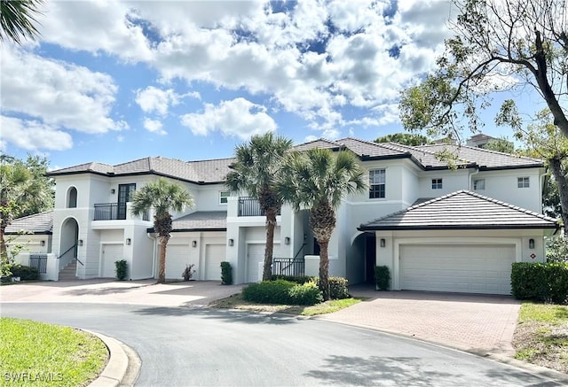 mediterranean / spanish home with stucco siding, driveway, and a balcony