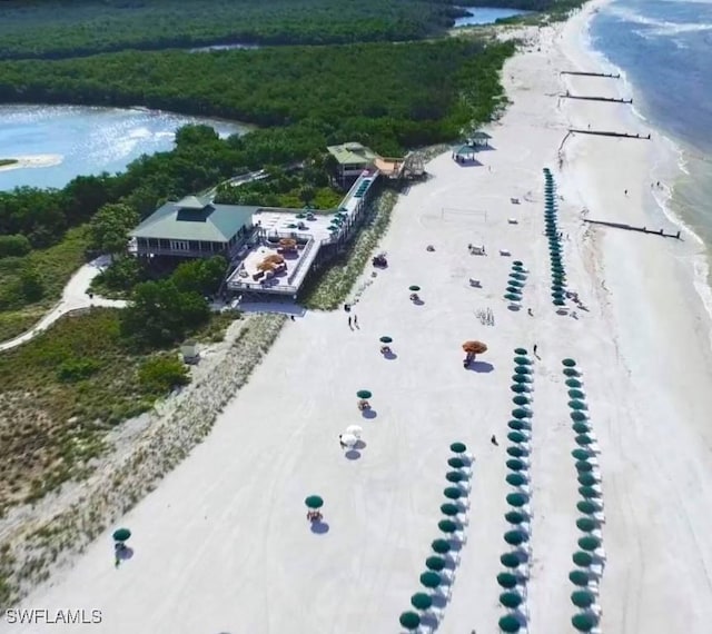 aerial view featuring a water view, a beach view, and a forest view