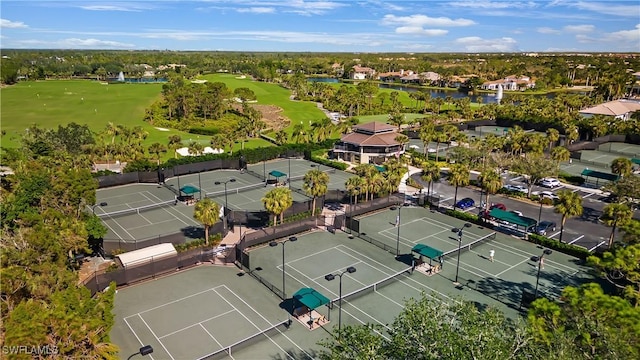 drone / aerial view with a water view, golf course view, and a residential view