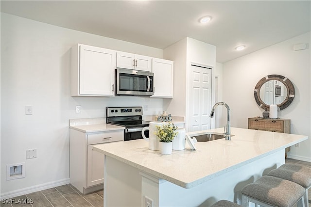 2810 29th St SW, Lehigh Acres, FL 33976 - kitchen with appliances with stainless steel finishes, a sink, a breakfast bar, and baseboards