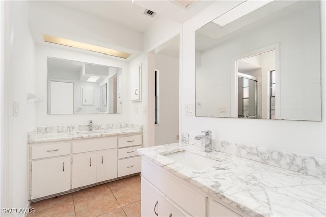 bathroom with two vanities, visible vents, tile patterned flooring, and a sink