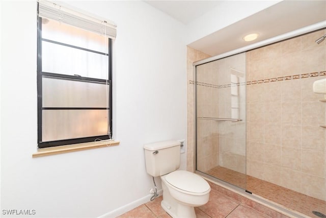 full bathroom featuring toilet, baseboards, tile patterned flooring, and a stall shower