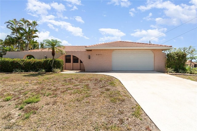 view of front of home featuring a garage, a tile roof, stucco siding, and driveway