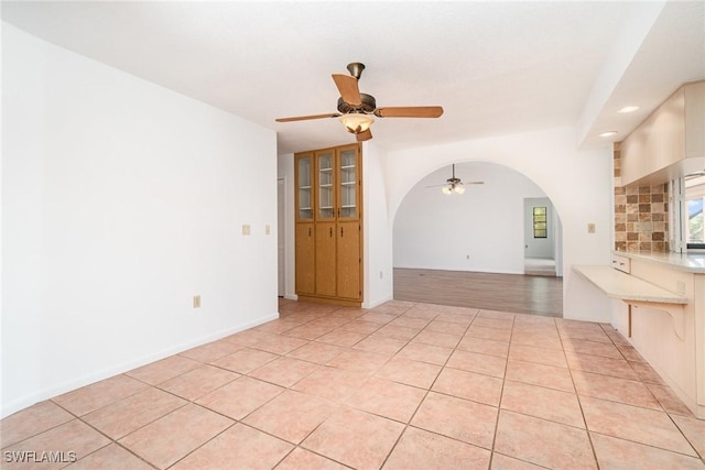 unfurnished living room with recessed lighting, ceiling fan, arched walkways, and light tile patterned floors