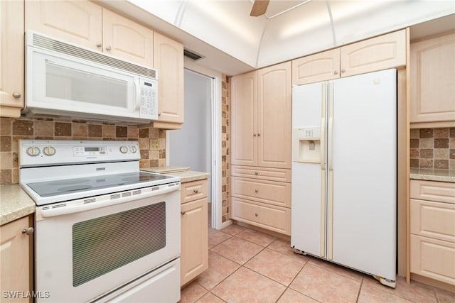 kitchen featuring light brown cabinetry, tasteful backsplash, white appliances, light countertops, and light tile patterned floors