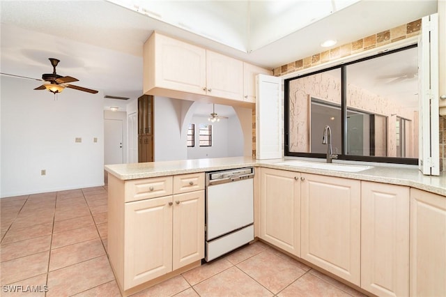 kitchen featuring a ceiling fan, white dishwasher, a sink, light tile patterned flooring, and light countertops
