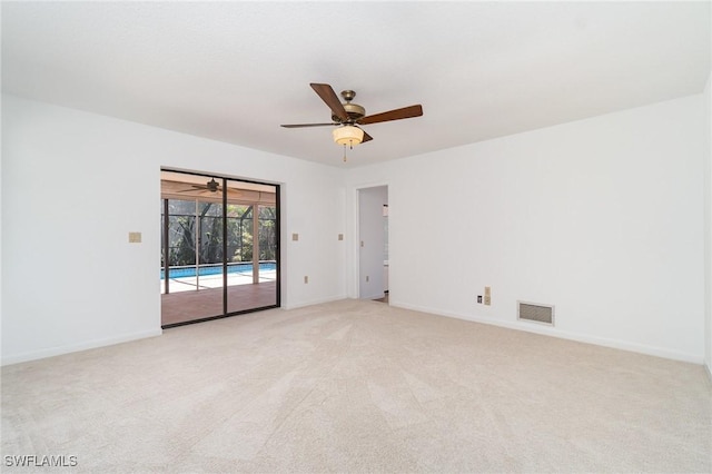 spare room featuring baseboards, visible vents, light colored carpet, and ceiling fan
