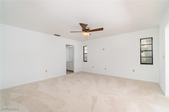 unfurnished room with baseboards, visible vents, light colored carpet, and ceiling fan