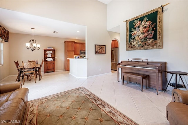 living room with visible vents, arched walkways, light tile patterned floors, baseboards, and a notable chandelier