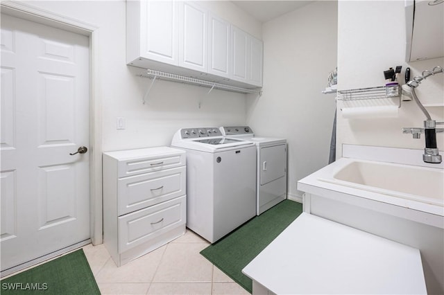 washroom featuring cabinet space, separate washer and dryer, a sink, and light tile patterned floors