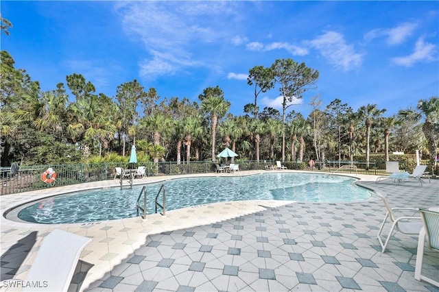 community pool featuring a patio and fence