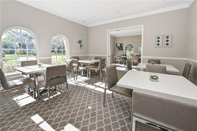 dining area featuring wainscoting, ornamental molding, and carpet