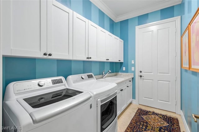 laundry area with a sink, cabinet space, washing machine and dryer, baseboards, and ornamental molding
