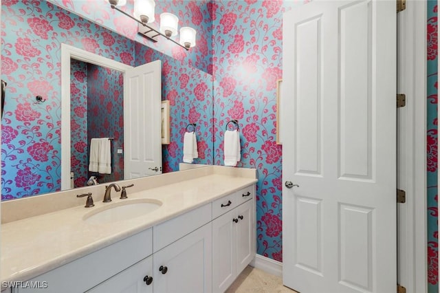 bathroom with wallpapered walls and vanity