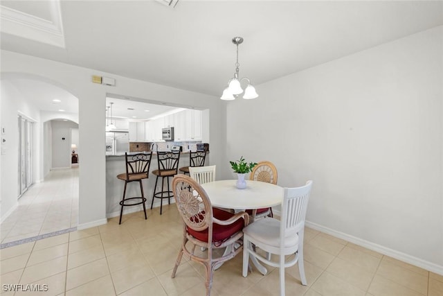 9046 Astonia Way, Estero, FL 33967 - dining space featuring arched walkways, a chandelier, baseboards, and light tile patterned flooring