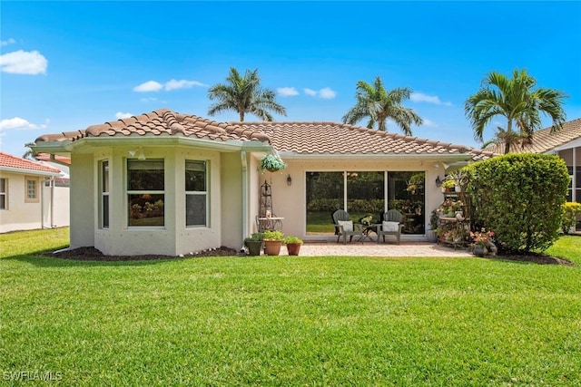 9046 Astonia Way, Estero, FL 33967 - rear view of property featuring a yard, a tile roof, a patio area, and stucco siding