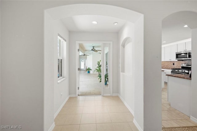9046 Astonia Way, Estero, FL 33967 - hall featuring arched walkways, baseboards, light tile patterned flooring, and recessed lighting
