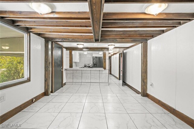 corridor with marble finish floor and baseboards