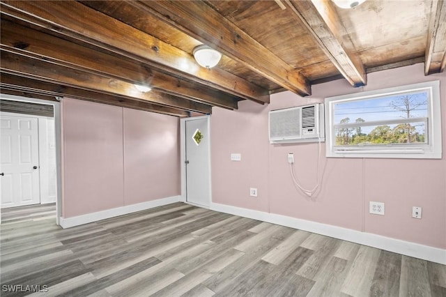 basement with a wall mounted air conditioner, wooden ceiling, wood finished floors, and baseboards