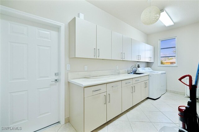 laundry room with baseboards, cabinet space, light tile patterned flooring, and independent washer and dryer