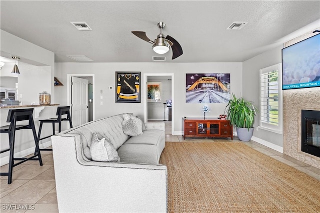 living area with visible vents and light tile patterned floors