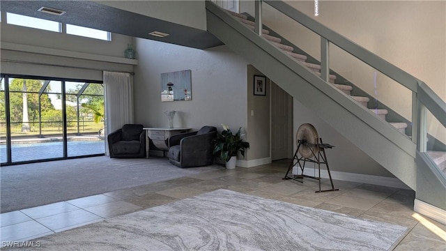 interior space with baseboards, visible vents, tile patterned flooring, and carpet