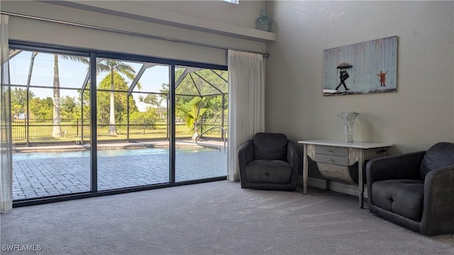 sitting room featuring a sunroom, carpet floors, and a healthy amount of sunlight
