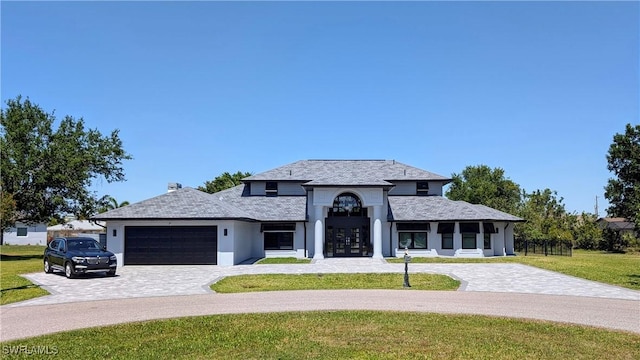 french provincial home with a front lawn, stucco siding, french doors, decorative driveway, and a garage