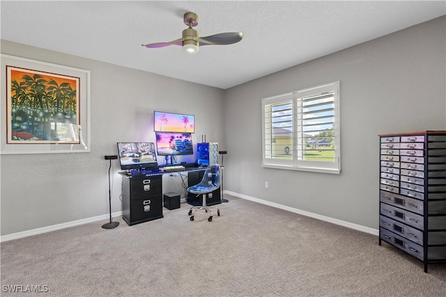 carpeted home office with a ceiling fan and baseboards