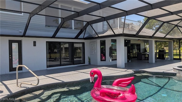 rear view of house with an outdoor pool, a patio area, glass enclosure, and a ceiling fan