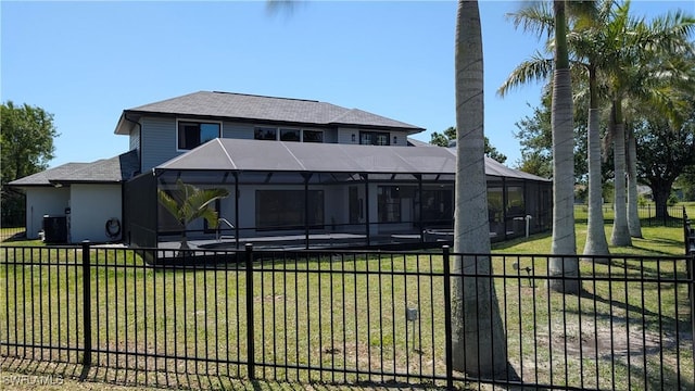 back of house with glass enclosure, roof with shingles, a fenced backyard, a yard, and a patio