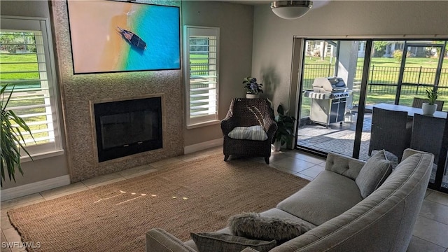 living area featuring baseboards, tile patterned flooring, and a healthy amount of sunlight