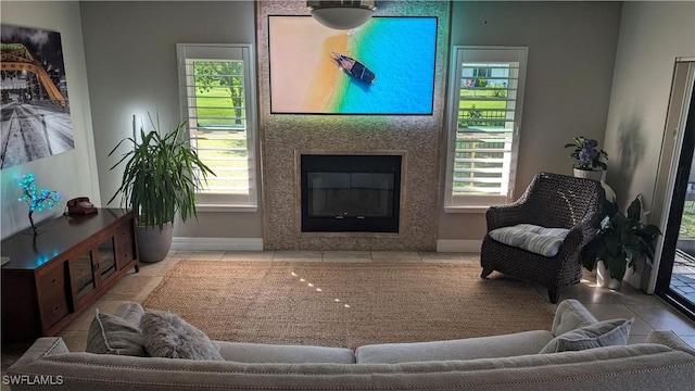 living room with baseboards, a glass covered fireplace, and plenty of natural light