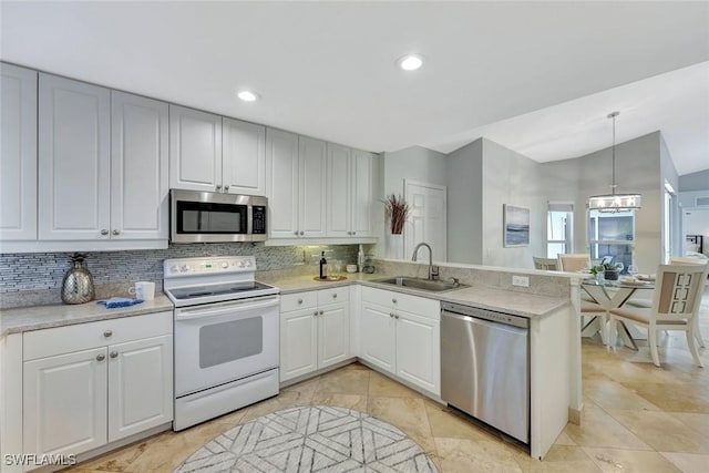 11499 Forest Mere Dr, Bonita Springs, FL 34135 - kitchen featuring stainless steel appliances, vaulted ceiling, a sink, decorative backsplash, and a peninsula