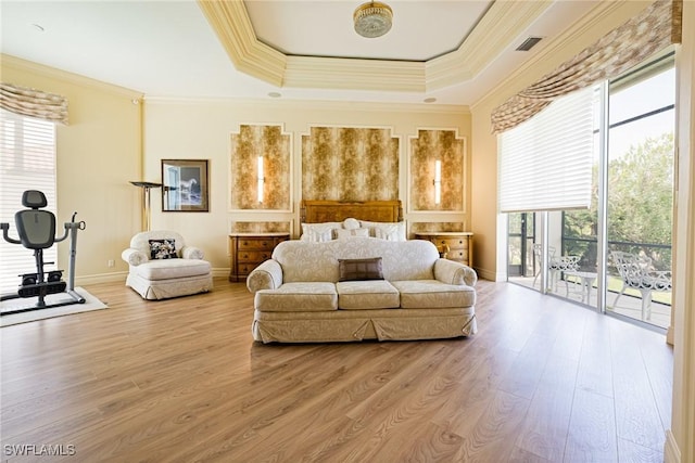 bedroom featuring access to exterior, a tray ceiling, wood finished floors, crown molding, and baseboards